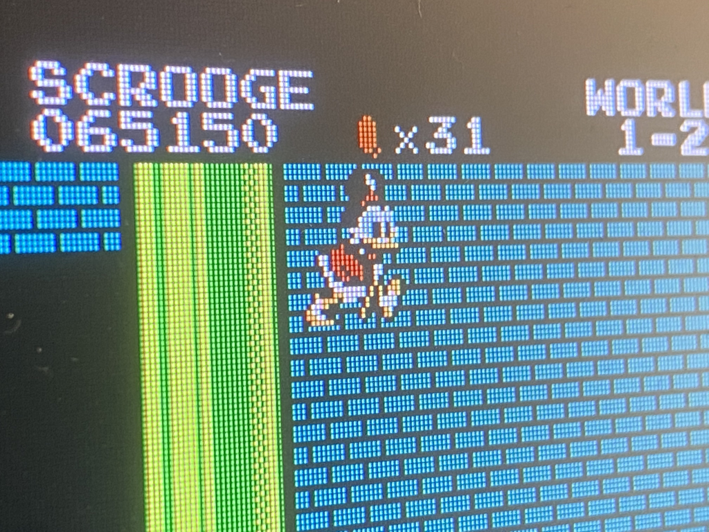 a composite image of Scrooge McDuck (from the Capcom DuckTales game) performing the Minus World glitch in level 1-2 of the original Super Mario Bros